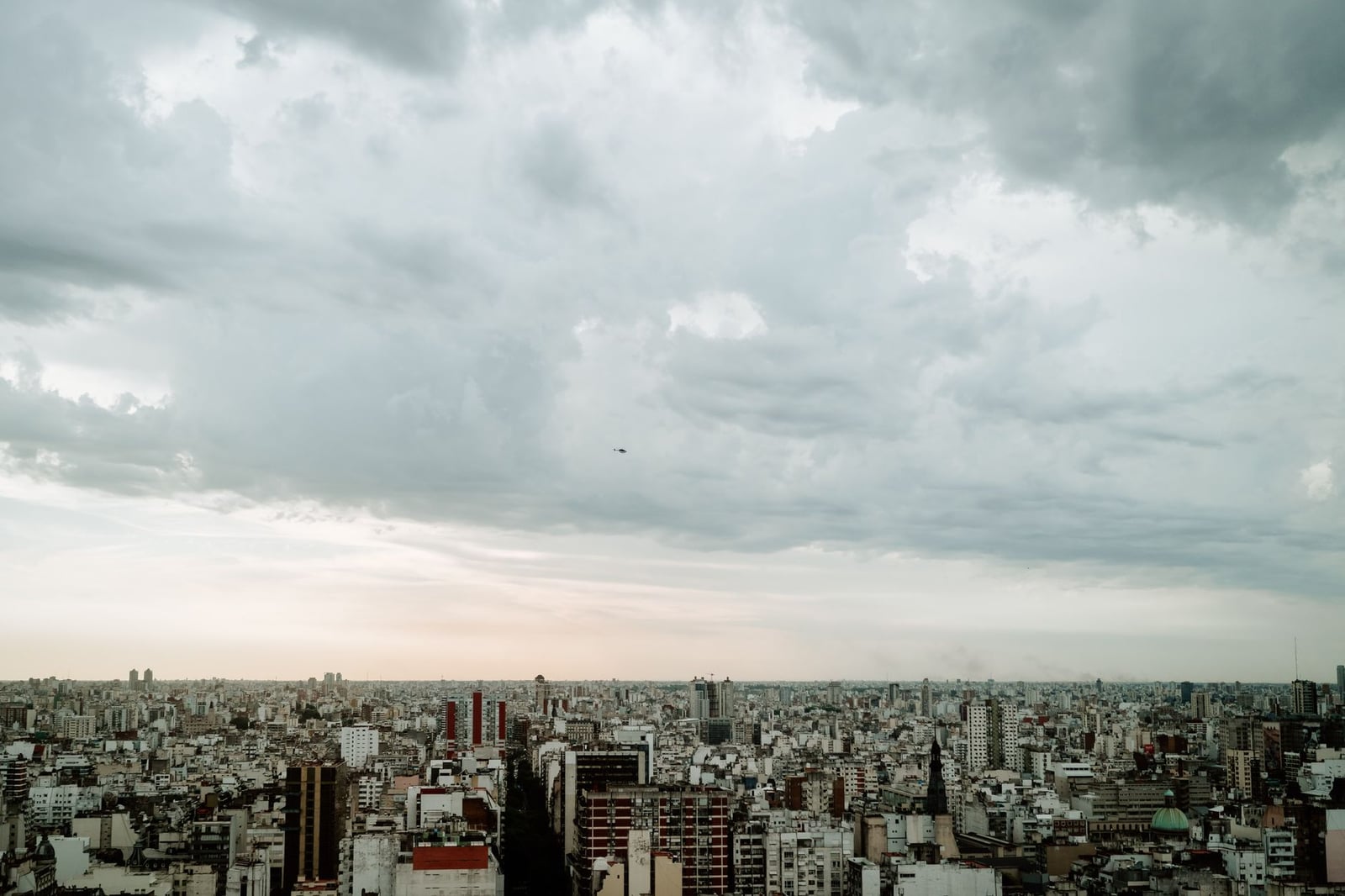 Una vista aérea panorámica del horizonte de Buenos Aires bajo un cielo nublado, enfatizando la densidad urbana.