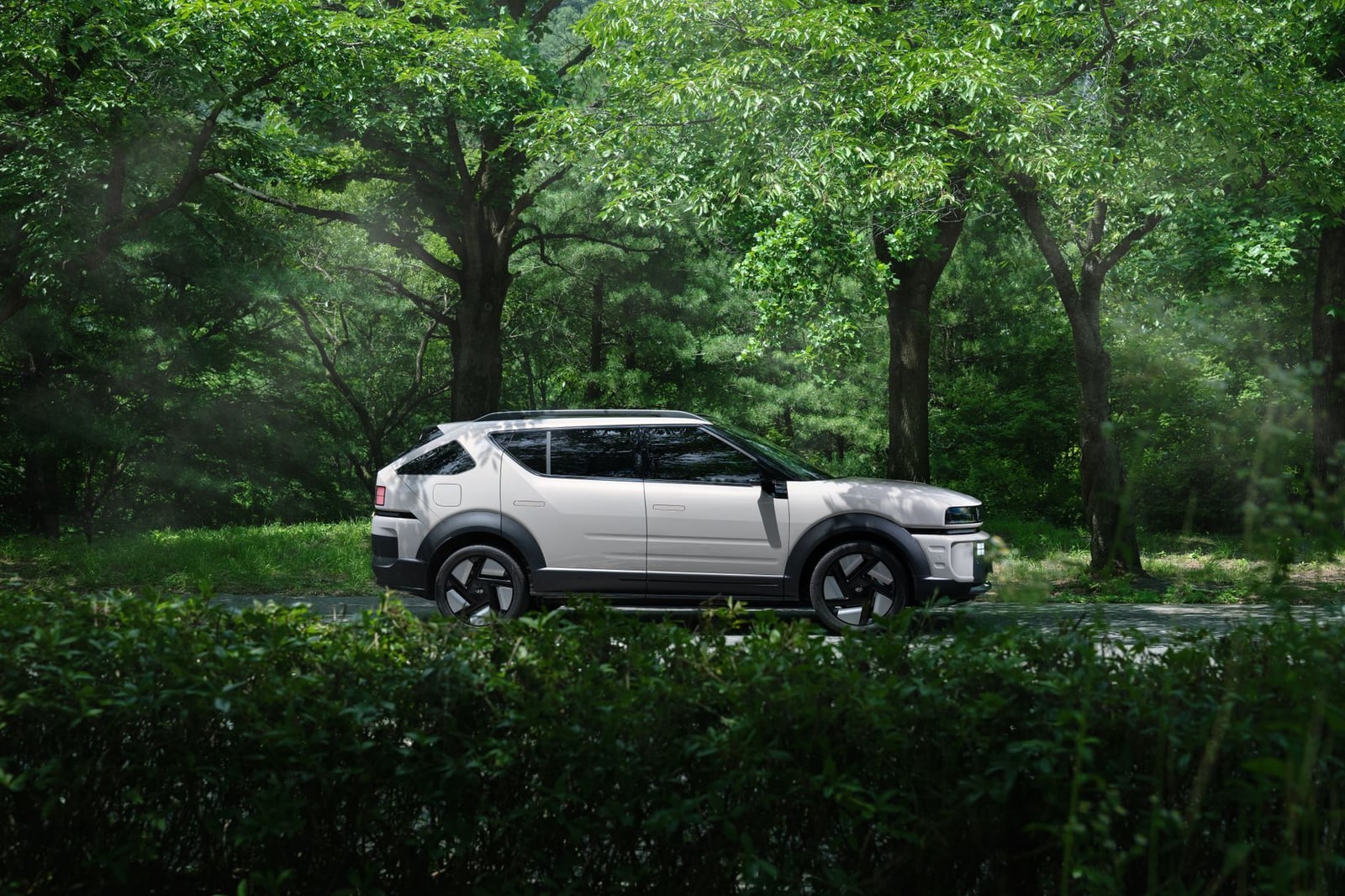 Un SUV eléctrico moderno estacionado en un bosque sereno, combinando naturaleza y tecnología.