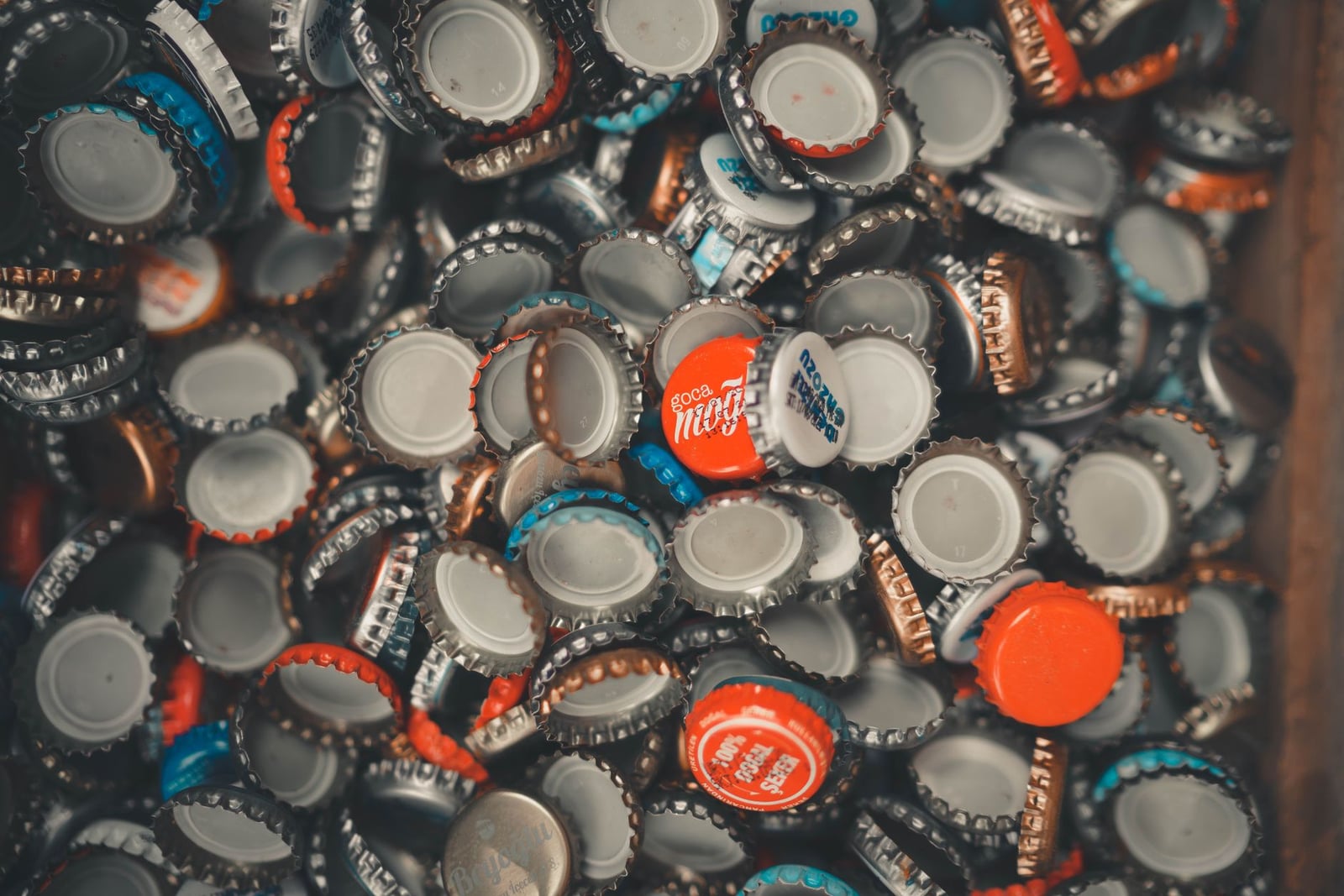 Una colección vibrante de tapitas de botellas mezcladas que muestran varios colores y marcas.