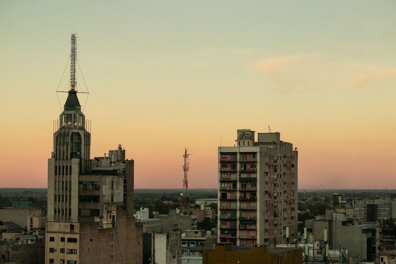 Vista del horizonte de la ciudad de Mendoza al atardecer, con edificios y torres prominentes.