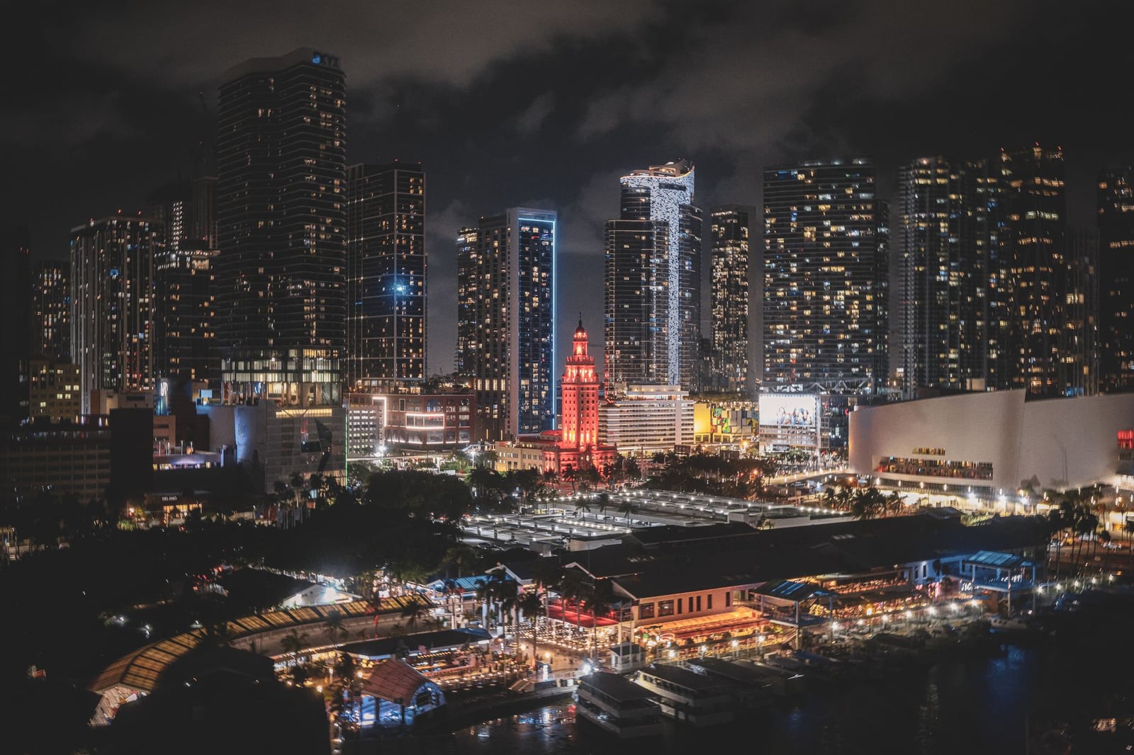El vibrante horizonte del centro de Miami por la noche, con sus rascacielos iluminados y el bullicioso ambiente de la ciudad.