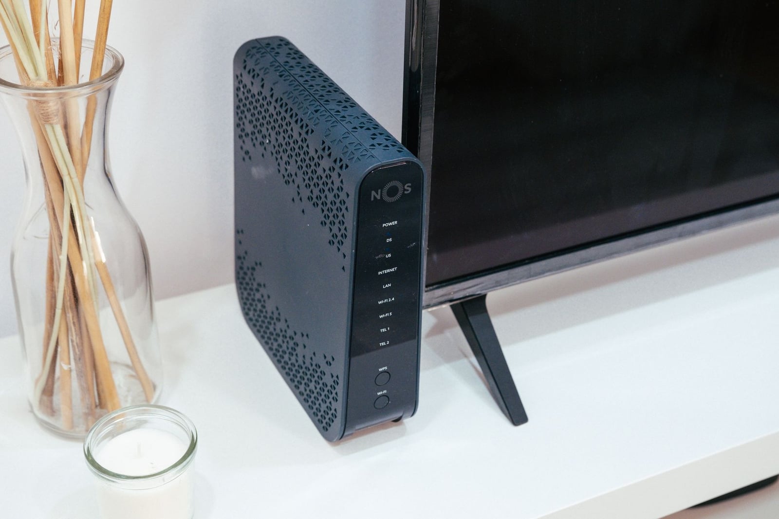 Una elegante configuración de tecnología en casa con un router, decoración de vidrio y televisión.