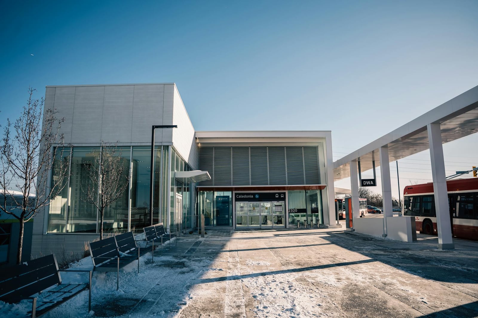 Exterior de una estación de tránsito contemporánea bajo un cielo azul claro en un soleado día de invierno.
