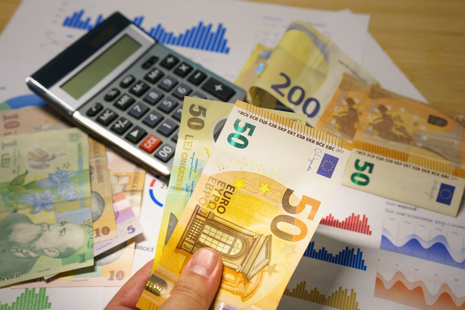 Monedas Euro y Lei rumana con calculadora en una configuración de escritorio financiero.