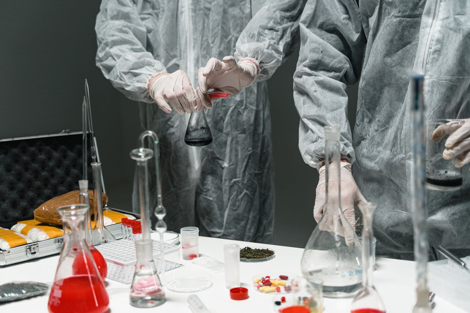 Investigadores con equipo de protección realizando experimentos en un laboratorio científico.