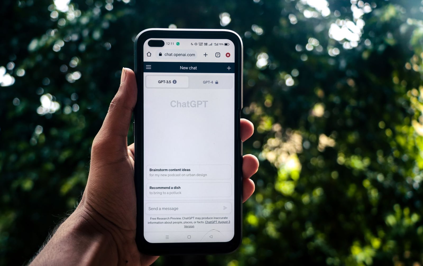 Una persona utiliza ChatGPT en un smartphone al aire libre, demostrando la tecnología en la vida cotidiana.