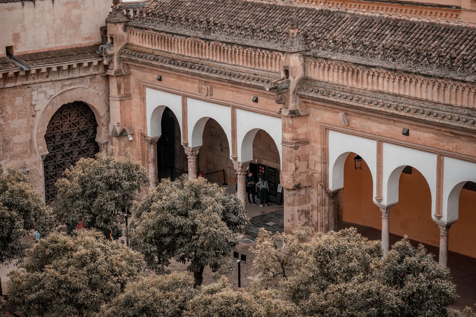 Vista aérea de la histórica Mezquita-Catedral de Córdoba con sus arcos icónicos y árboles circundantes.