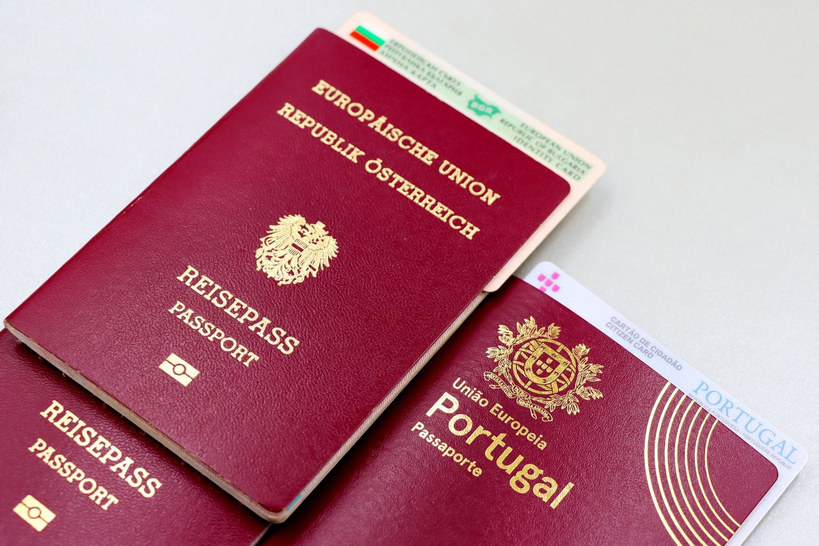 Una imagen de primer plano de pasaportes austriacos y portugueses con un documento de identidad búlgaro.