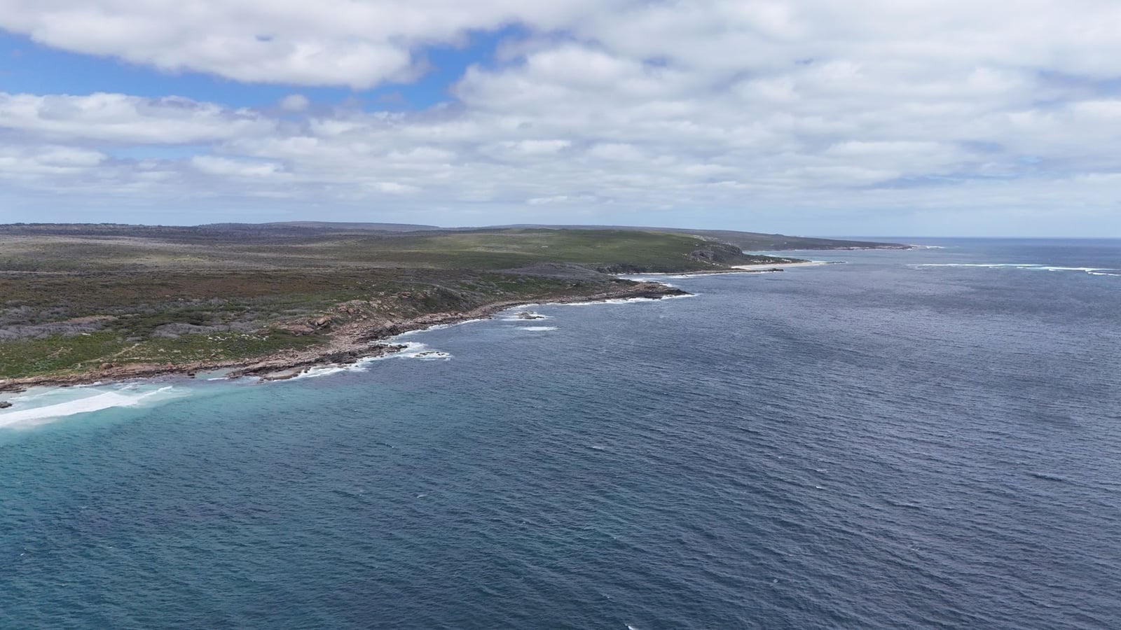 Impresionante vista aérea de la costa rugosa en Australia Occidental, con océano claro y paisajes rocosos.