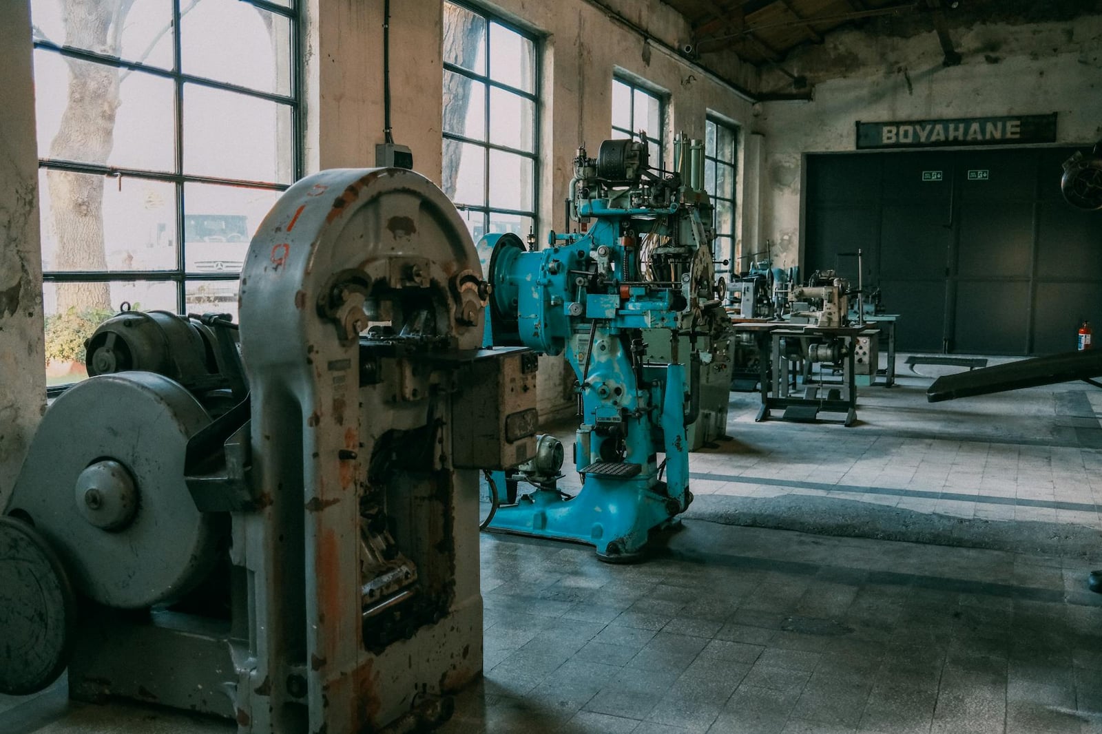 Interior de una antigua fábrica que muestra máquinas y equipos antiguos.