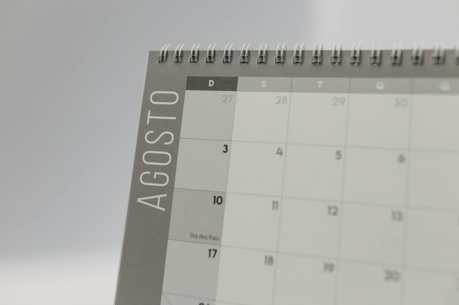 Primer plano de un calendario encuadernado en espiral que destaca las fechas de agosto.