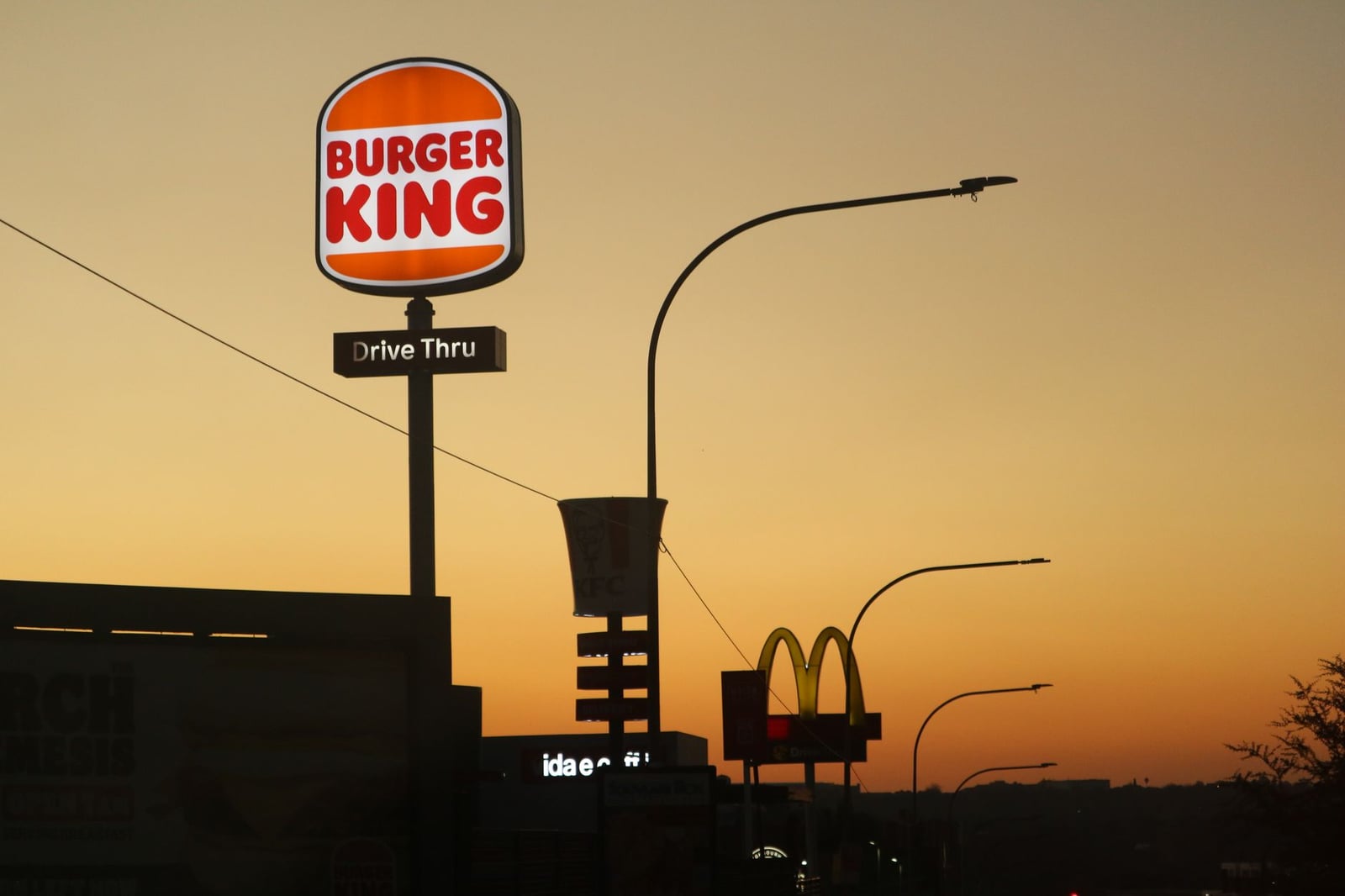 Silueta de los letreros de Burger King y McDonald's al atardecer en Johannesburgo.