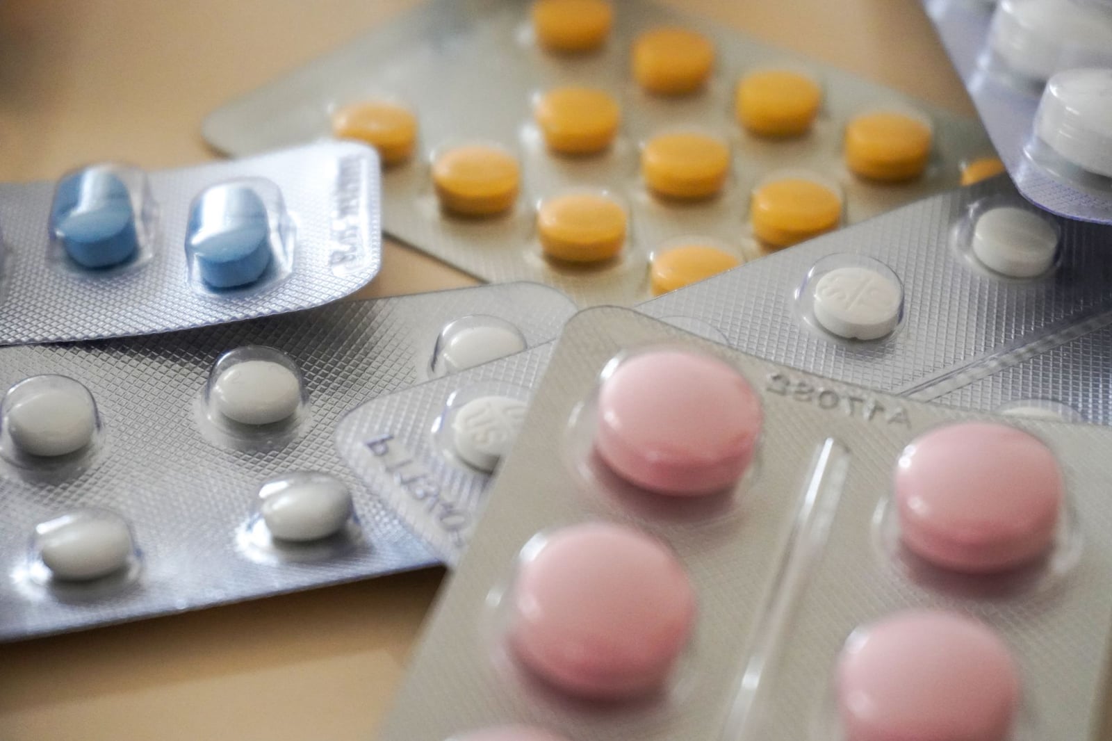 Vista en primer plano de blísteres de medicamentos coloridos variados con diversas píldoras.
