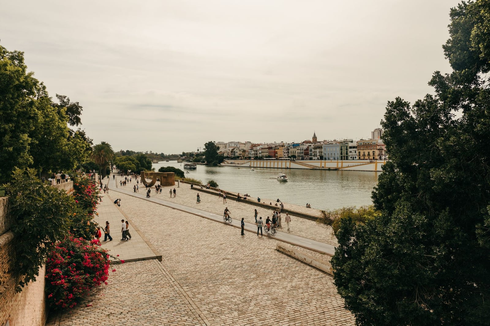 La gente disfruta de un pintoresco paseo fluvial a lo largo del río Guadalquivir en Sevilla, España.