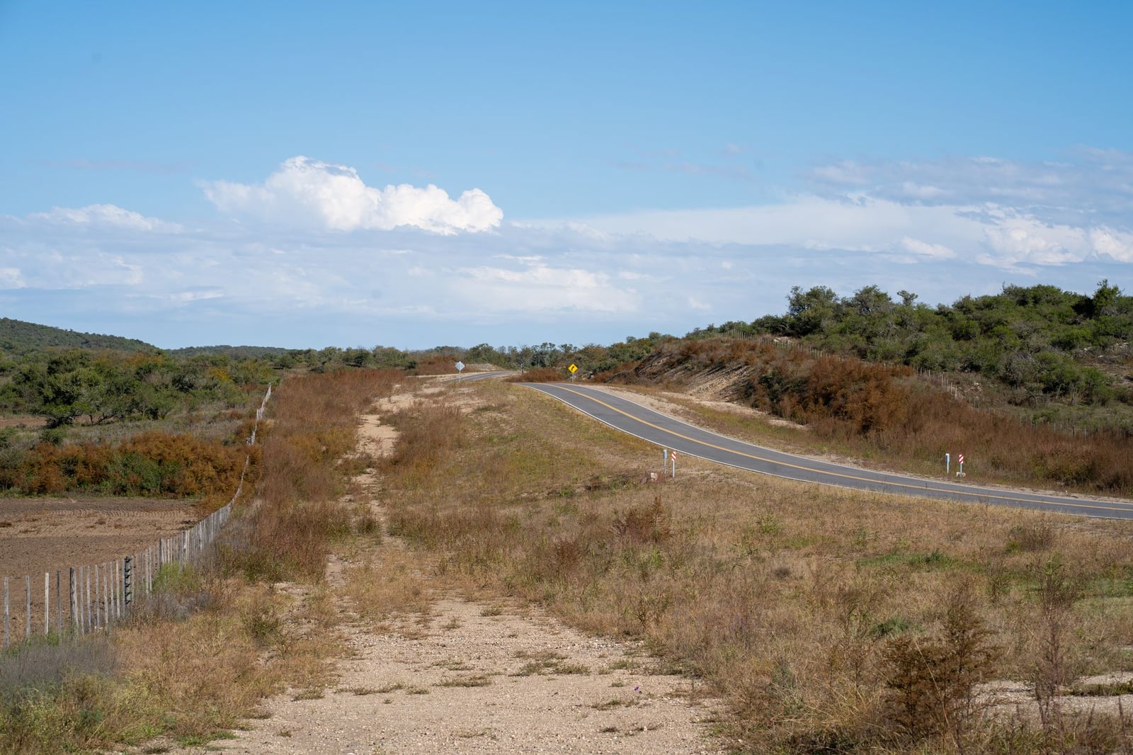 Tranquilo paisaje rural con una carretera que serpentea por el Río de los Sauces, Córdoba, Argentina.