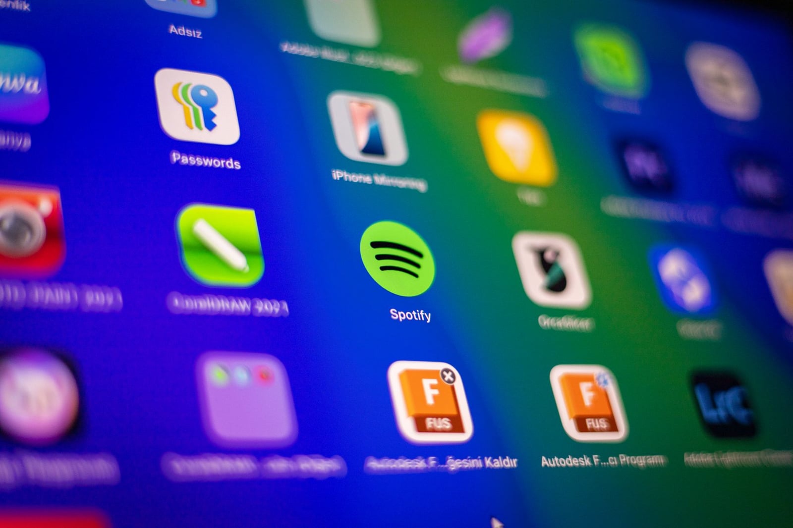 Primer plano borroso de íconos de aplicaciones vibrantes en la pantalla de un teléfono inteligente que muestran Spotify y más.
