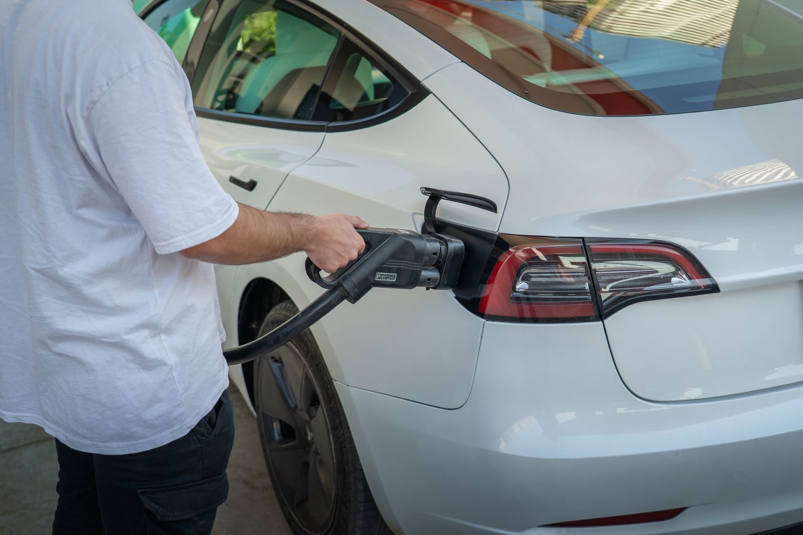 Coche eléctrico cargándose en una estación, lo que pone de relieve el transporte ecológico.