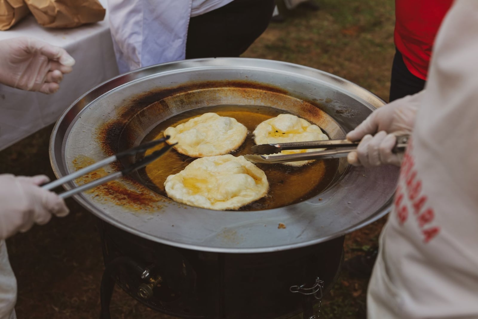 Personas cocinando masa frita tradicional al aire libre en Croacia.