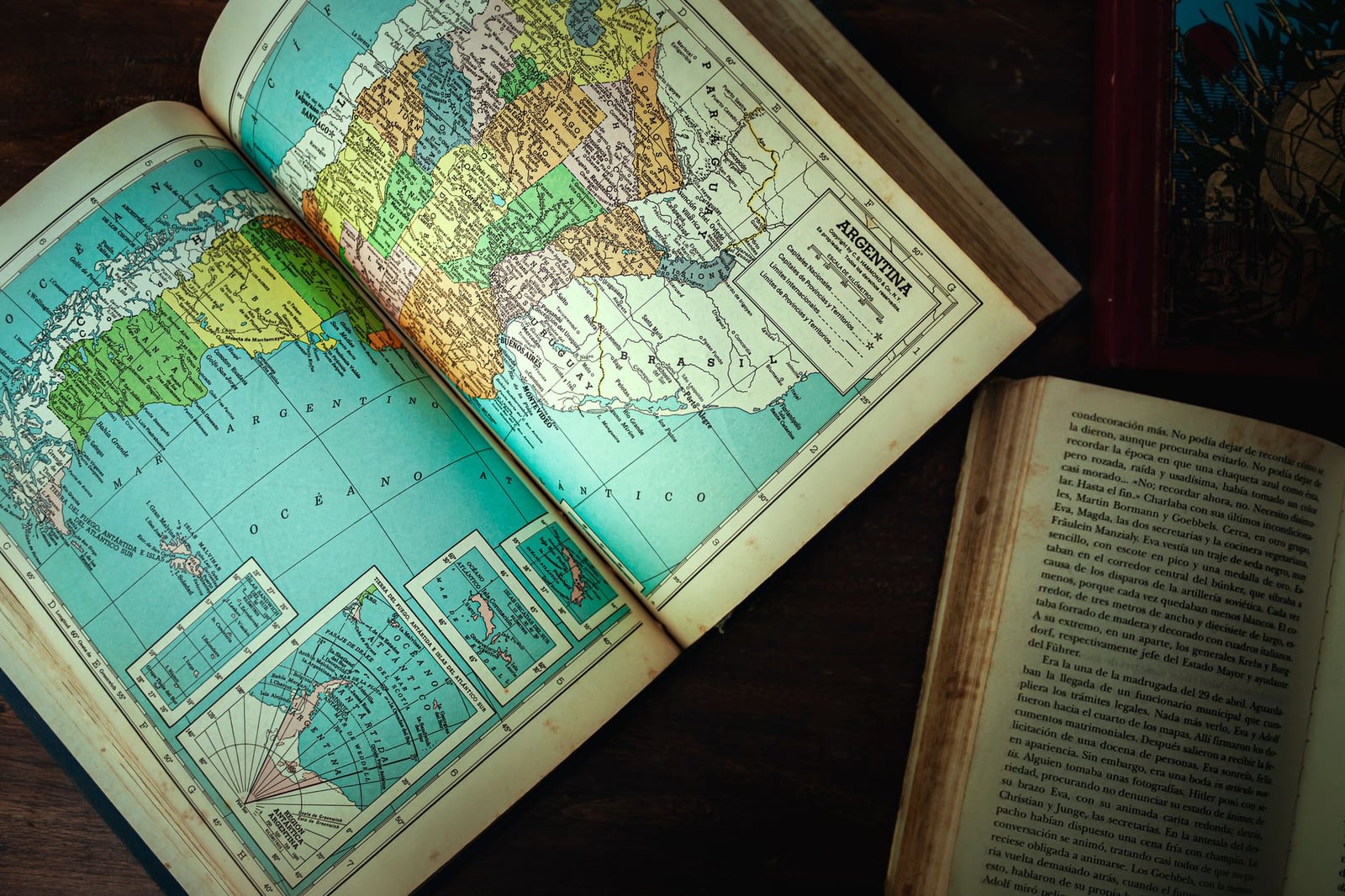 Explora un mapa antiguo de Argentina y libros vintage sobre una mesa de madera.