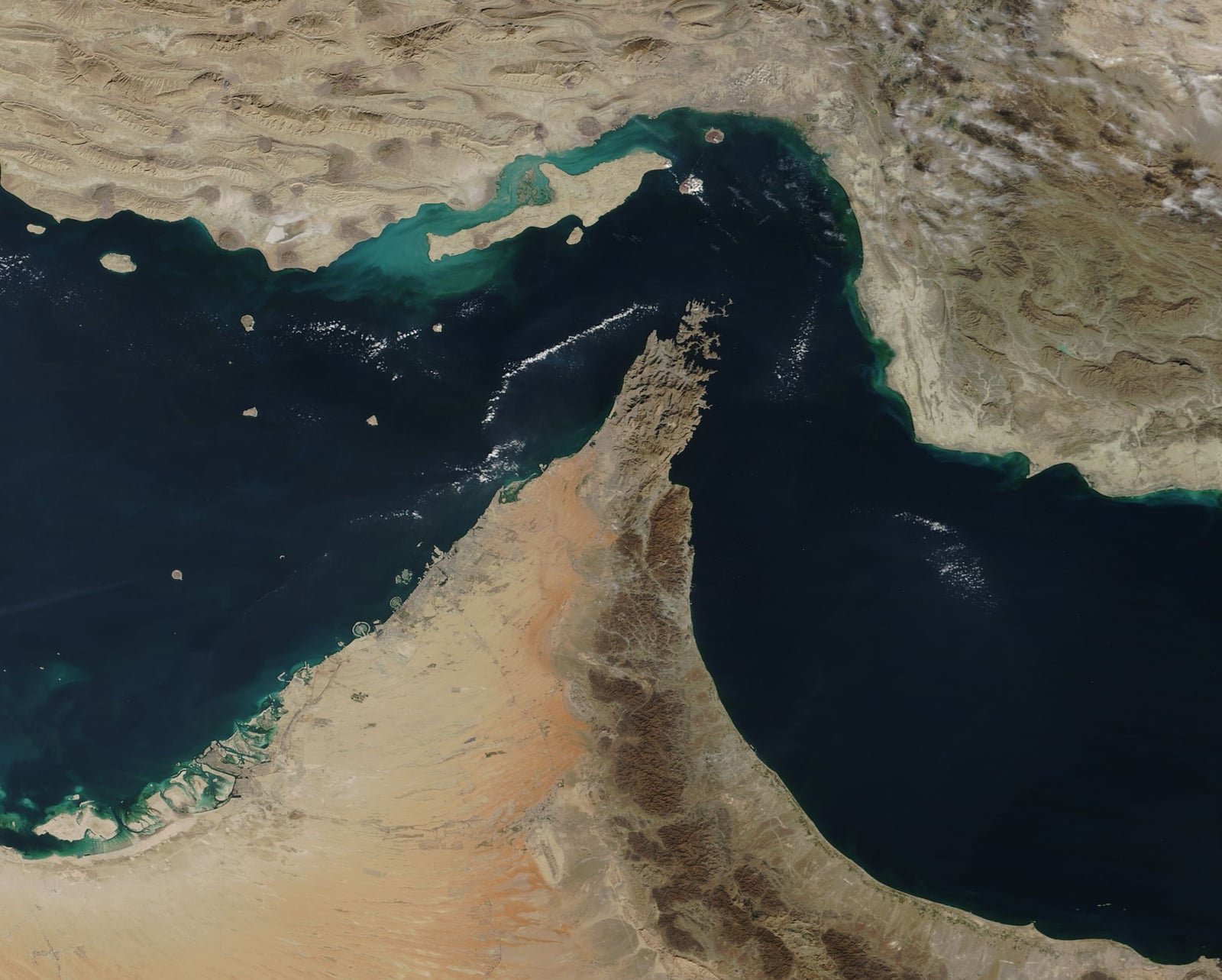 The rugged, barren mountains of the Musandam Peninsula jut into the Strait of Hormuz, the narrow throughway between Iran (north) and Oman and the United Arab Emirates (south) where the waters from the