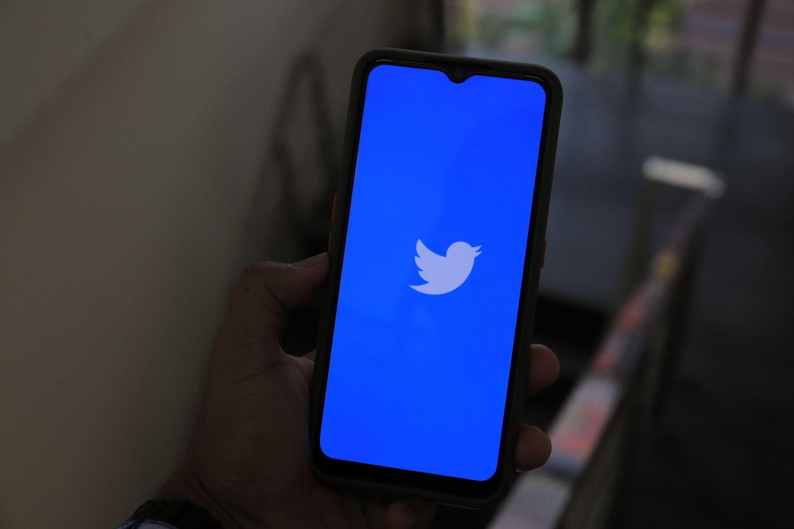 Acercamiento de una mano sosteniendo un smartphone que muestra la pantalla de la aplicación Twitter.