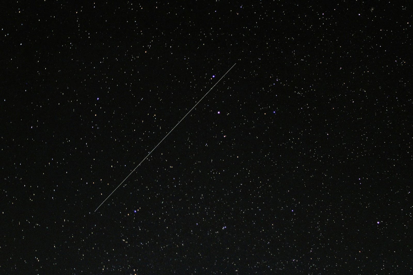 Cautivador cielo nocturno estrellado con una estrella fugaz visible atravesando el fondo cósmico.