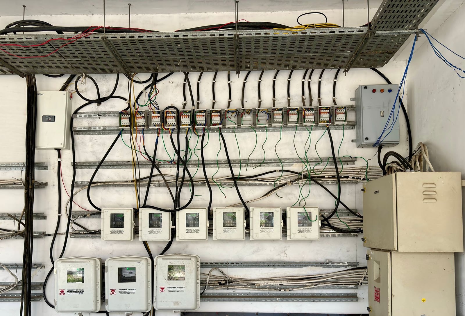 Red compleja de cableado eléctrico y paneles de control en un entorno industrial.