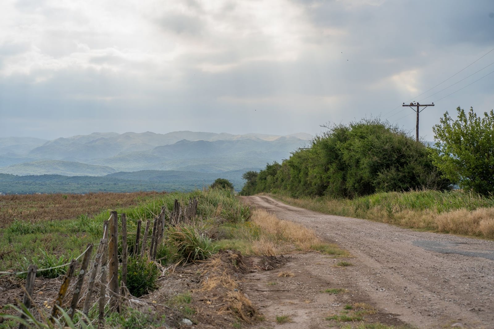 Tranquilo camino de tierra entre montañas y campos en Córdoba, Argentina.