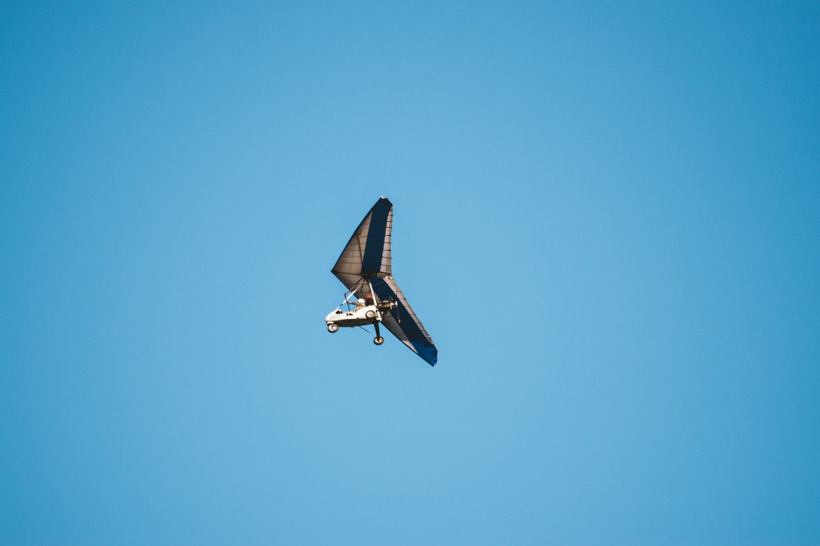 Una aeronave ultraligera volando en un cielo azul claro, capturando libertad y aventura.