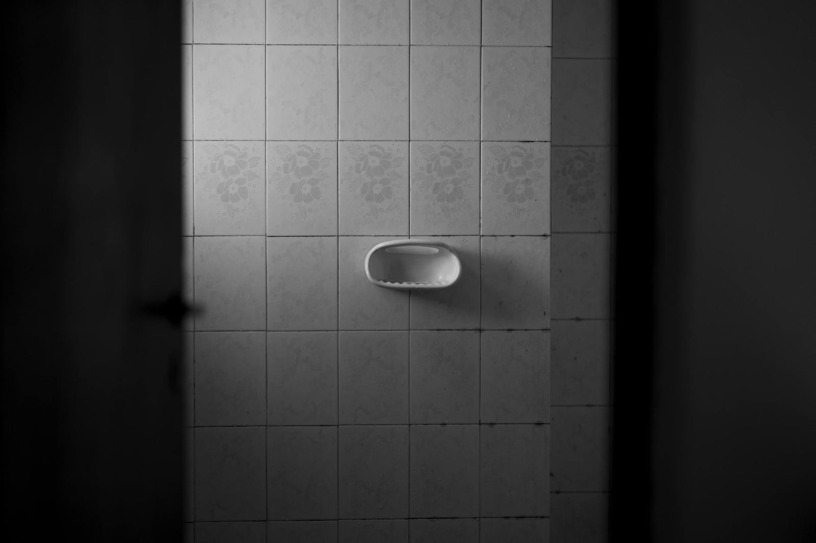 Un baño minimalista con paredes alicatadas y jabonera en Córdoba, Argentina.