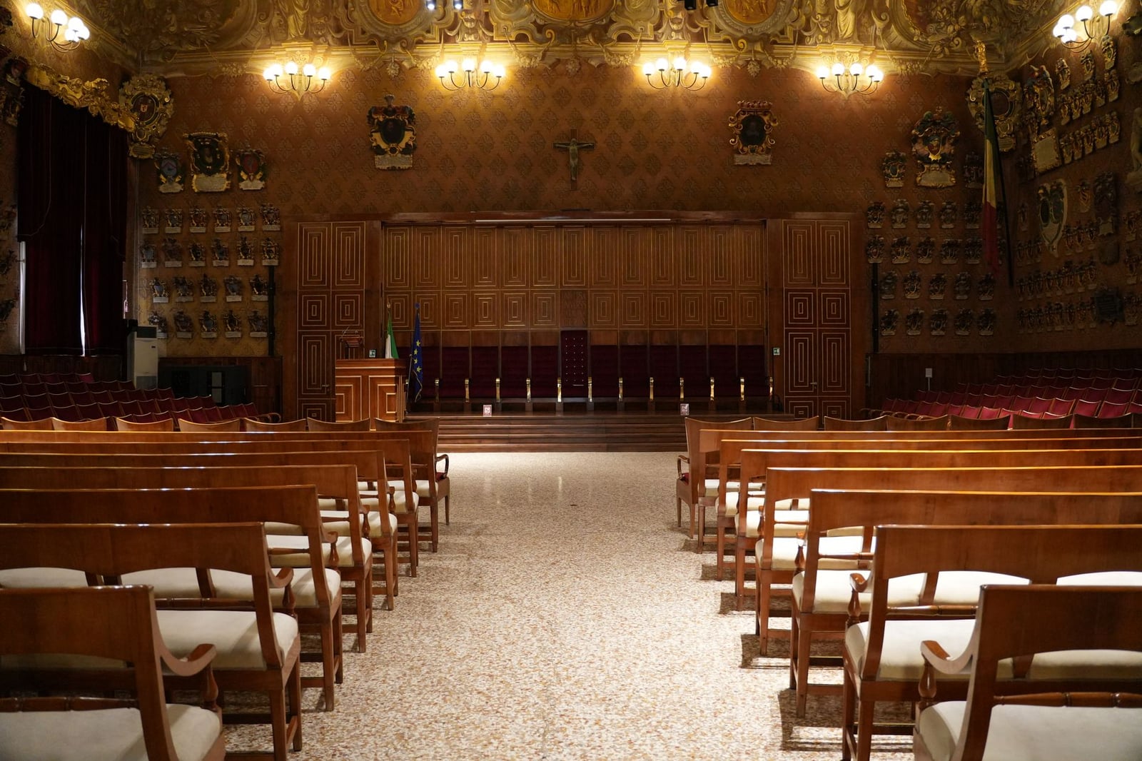 Vista interior de un auditorio histórico en Padua, Italia. Elegantes butacas de madera y decoración ornamentada.