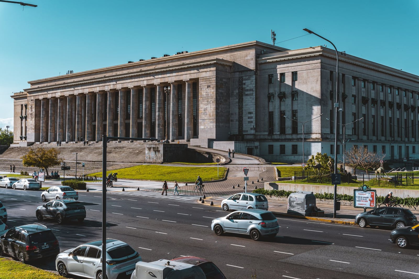 Vista del emblemático edificio de la Facultad de Derecho de Buenos Aires, rodeado de tráfico y la vida de la ciudad.