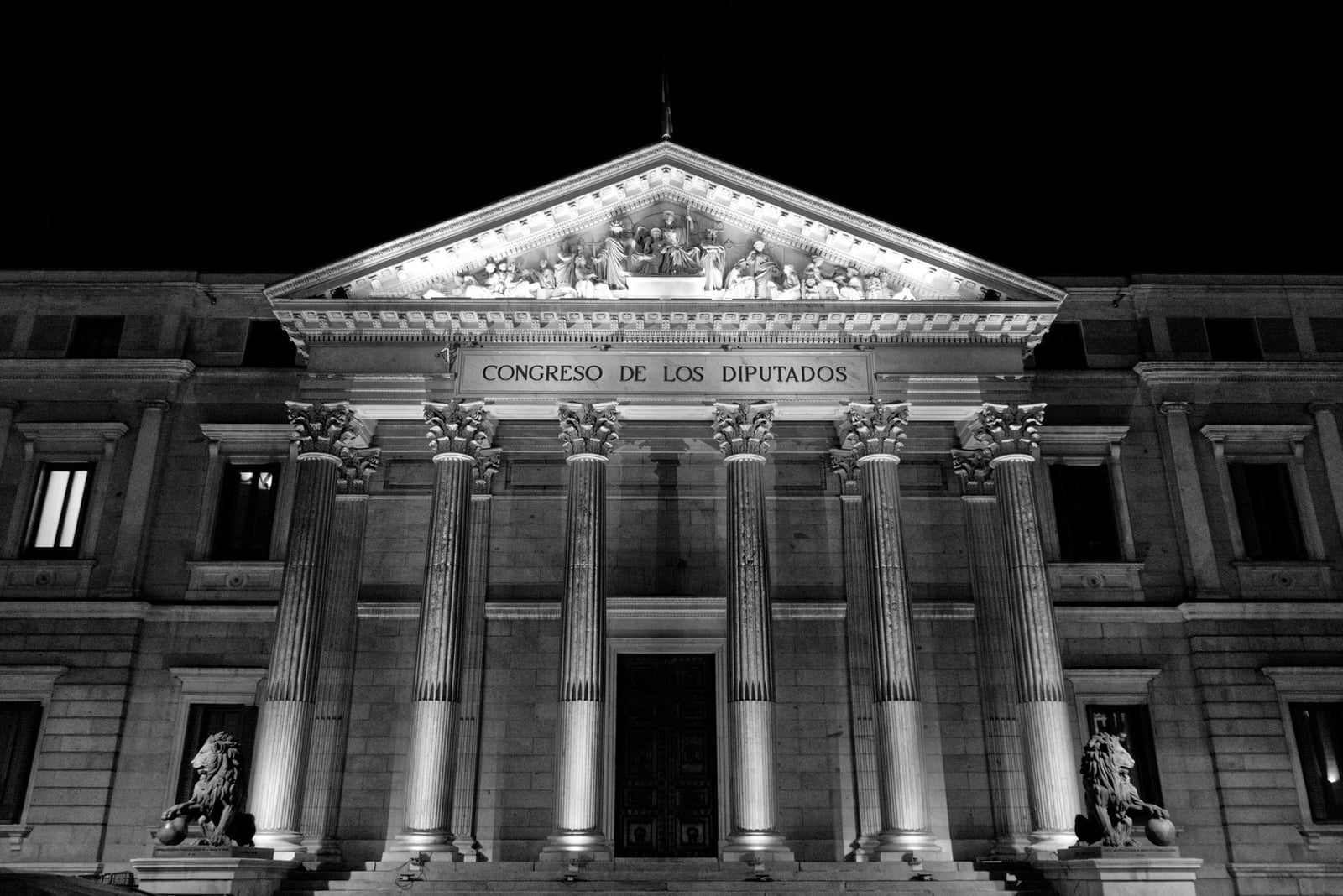 Foto en blanco y negro de la fachada del Congreso de los Diputados en Madrid de noche.