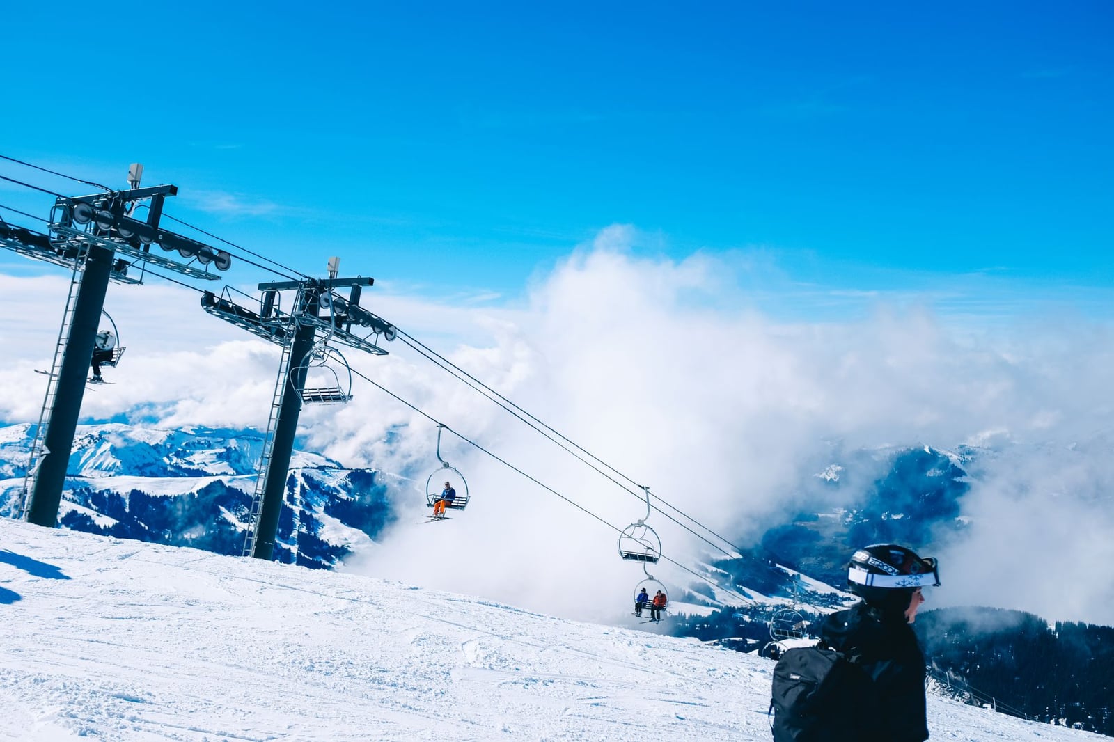 Esquiadores disfrutan de un brillante día de invierno en una montaña con un teleférico en un resort alpino.